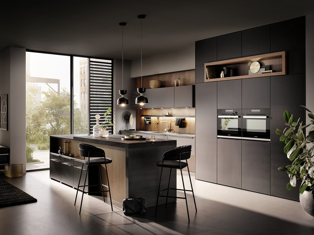 Black matte kitchen with wood-detail wall, pendant lights